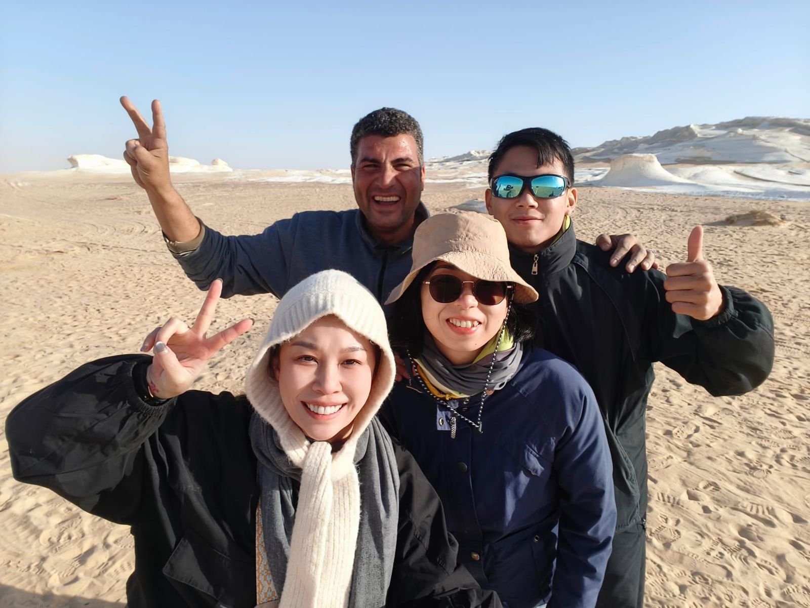 Taiwanese guests posing with their guide at a White Desert rock formation
