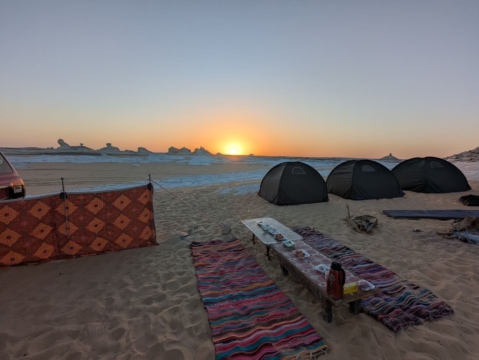 Golden hour over a desert camp at sunset